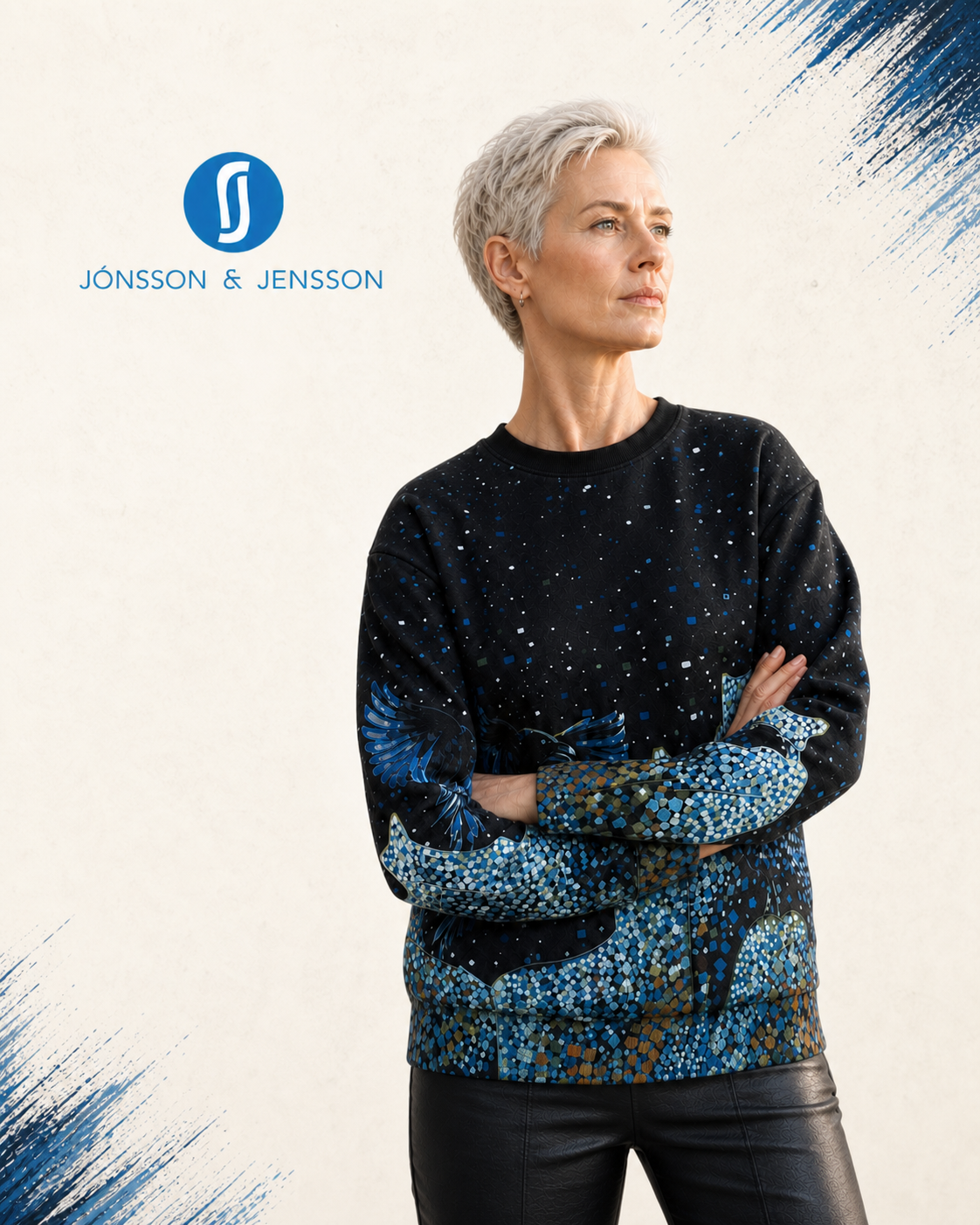 A woman with short blond hair wearing a black crewneck sweater with blue and teal abstract patterns, posed against a light beige background with blue graphic accents.